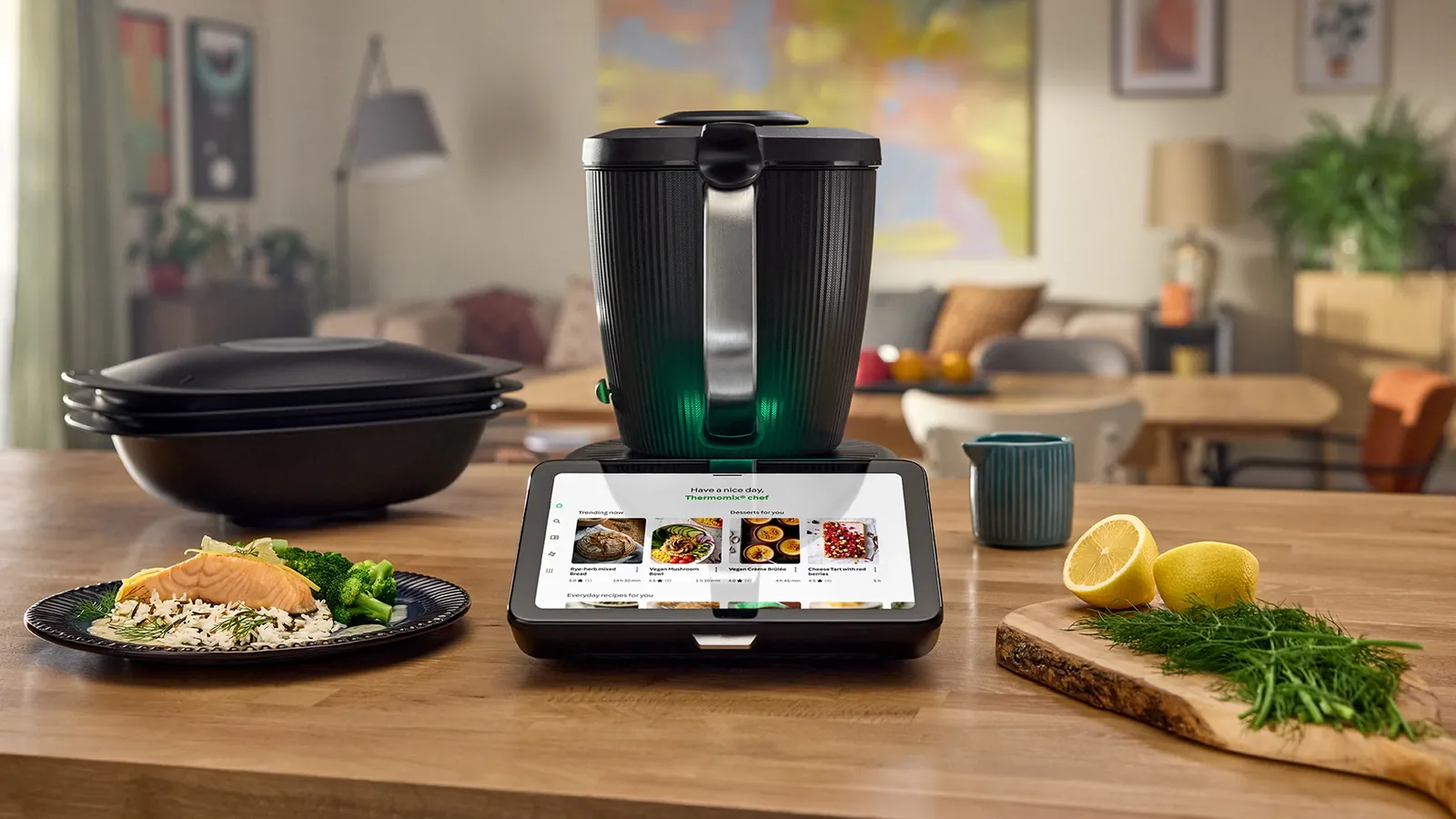 A Thermomix TM7 on a kitchen worktop beside a plated meal