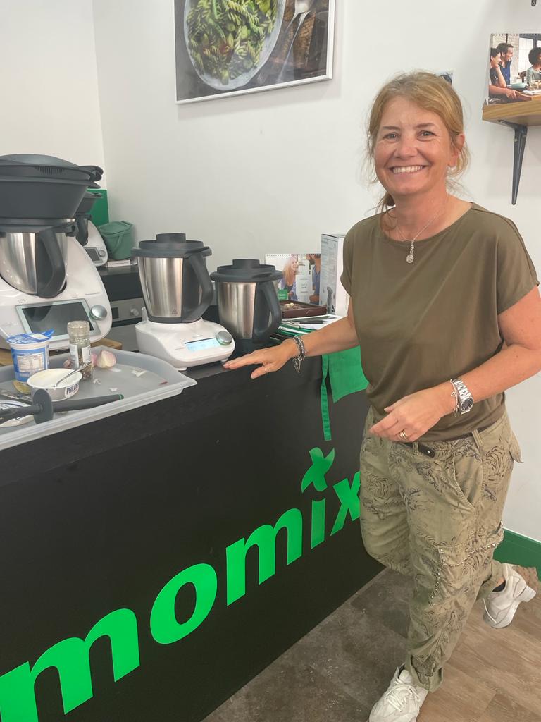 Isabella beside a row of Thermomix machines