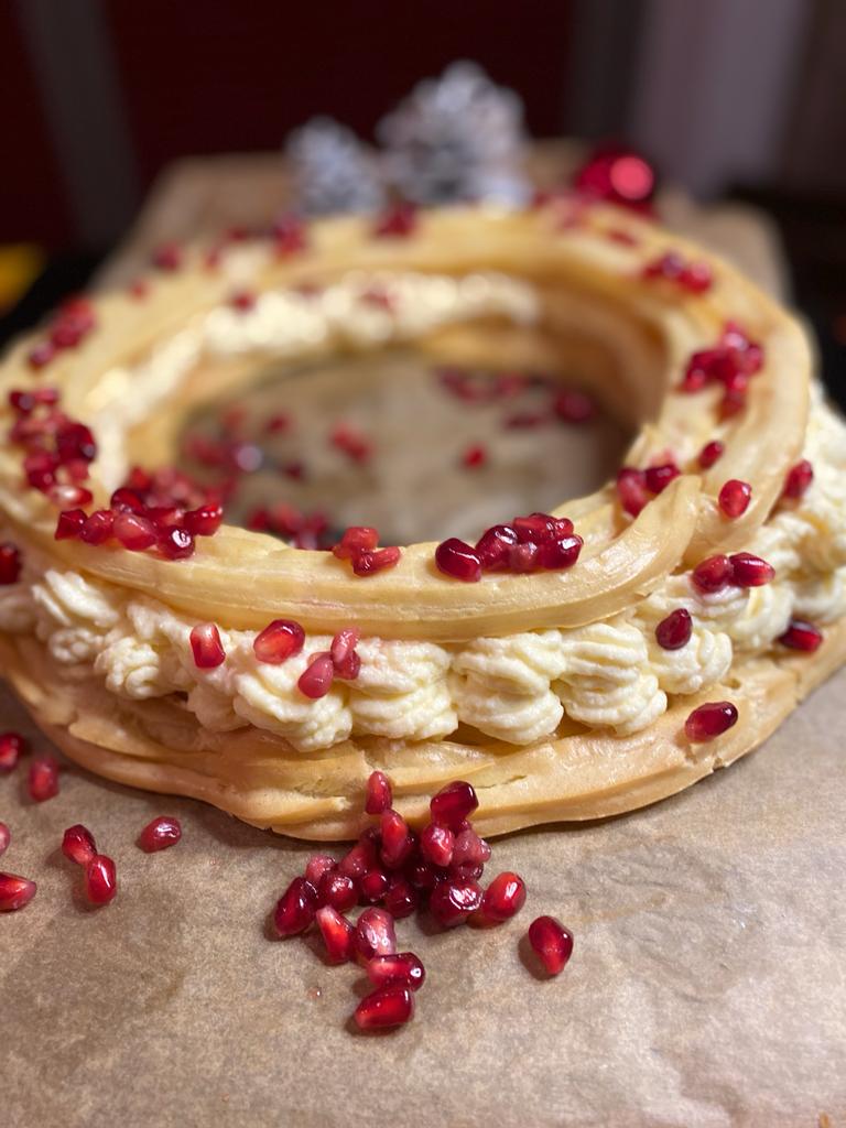 A pavlova wreath scattered with pomegranate seeds